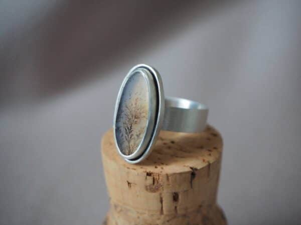 Handgemaakte zilveren ring met ovale dendrietagaat in zachte natuurtinten.
